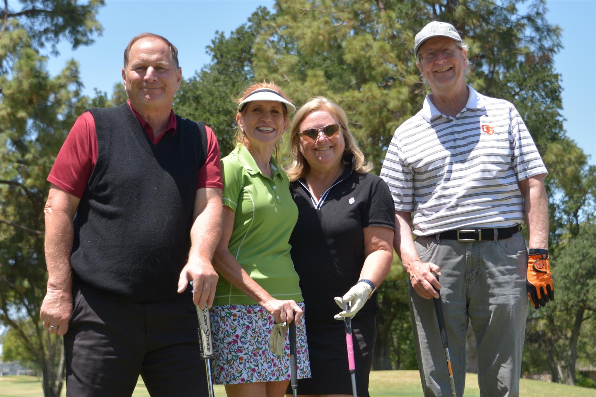 Photo of 2 men and 2 women at the annual Pwr Golf Tournament